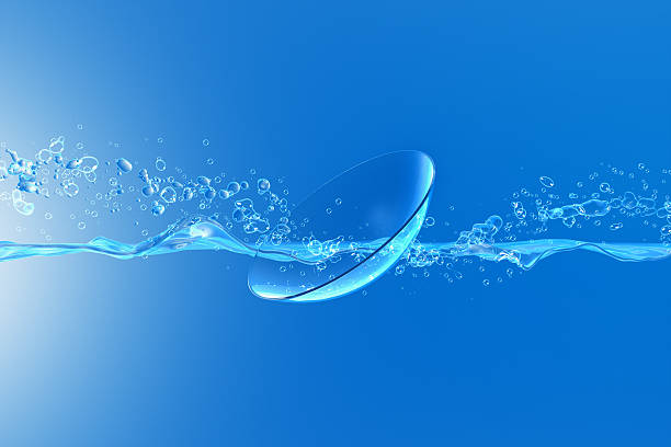 Contact Lens with splash A splash and air bubbles passing through a contact lens in a water environment contact lens photos stock pictures, royalty-free photos & images