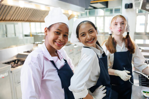 istock Group portrait young wman cooking student. Cooking class. culinary classroom. group of happy young woman multi - ethnic students are focusing on cooking lessons in a cooking school. 1564672061
