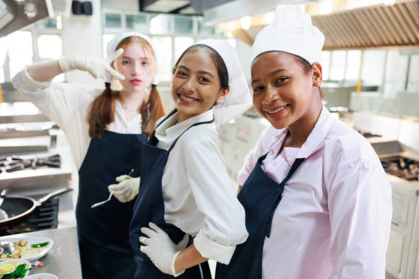 istock Group portrait young wman cooking student. Cooking class. culinary classroom. group of happy young woman multi - ethnic students are focusing on cooking lessons in a cooking school. 1564672073