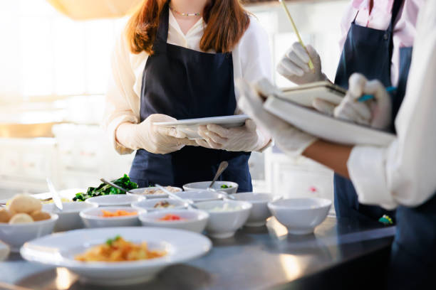 istock take note on book. Cooking class. culinary classroom. group of happy young woman multi-ethnic students are focusing on cooking lessons in a cooking school. 1564672223