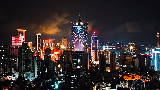 Cityscape view of Grand Lisboa Casino skyscraper building at Macau island, financial business or entertainment district. Drone aerial night view. Asia travel landmark concept