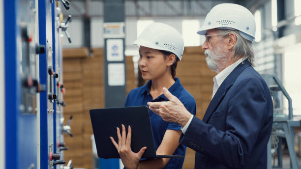 istock Professional male industrial engineers talk with factory worker while using laptop in manufacturing factory. Working in manufacturing plant or production plant. 1564696401