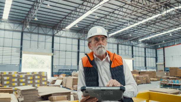 istock Professional male industrial engineers use tablet while standing in manufacturing factory. Working in manufacturing plant or production plant. 1564696424