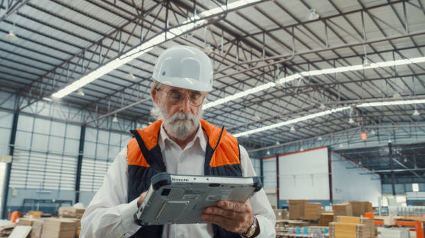 istock Professional male industrial engineers use tablet while standing in manufacturing factory. Working in manufacturing plant or production plant. 1564696430