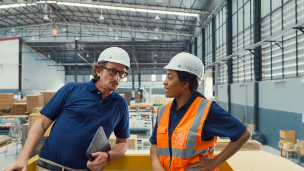 istock Professional male industrial engineers talk with factory worker while using tablet in manufacturing factory. Working in manufacturing plant or production plant. 1564696962