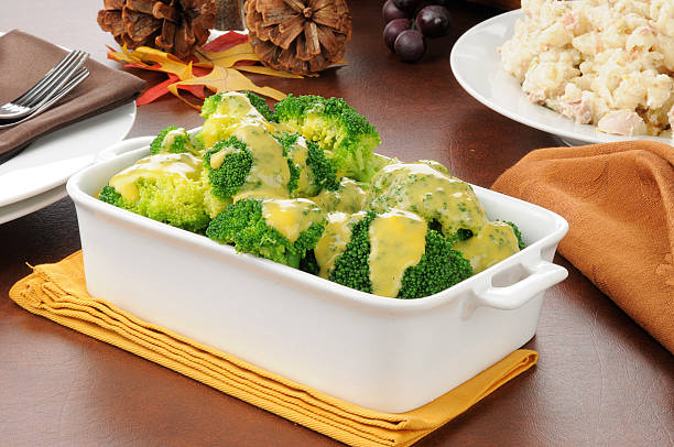 Broccoli with cheese sauce Broccoli with cheese sauce and a bowl of tuna casserole broccoli crowns stock pictures, royalty-free photos & images