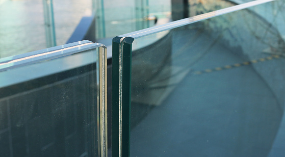 Closeup frameless laminated glass railing for modern architecture.