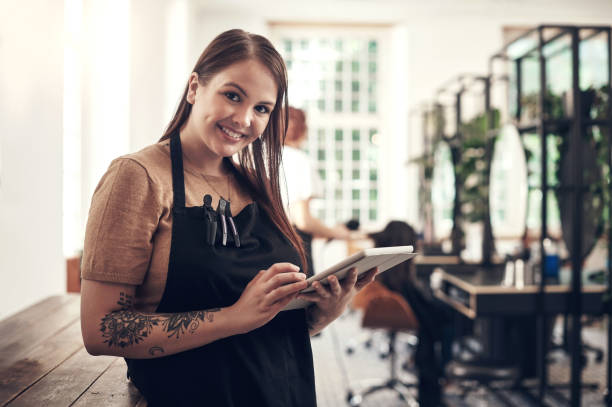 istock Shot of a hairstylist using a digital tablet at work 1564716805