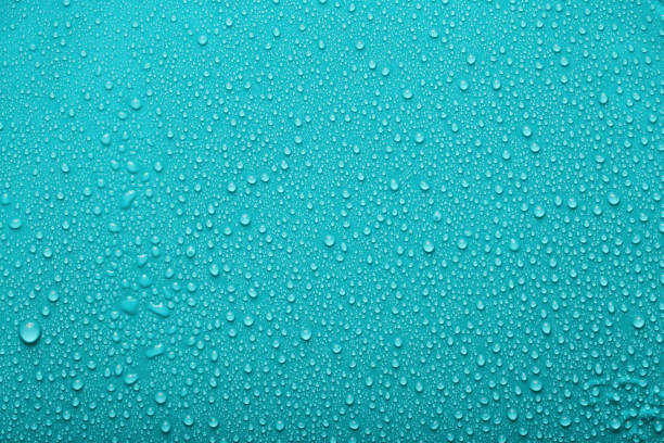 istock Small and large drops of water on a colored background. Abstract liquid sprays 1564719072