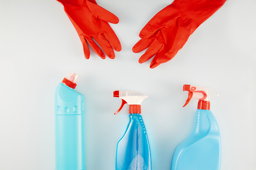 Washing Up Gloves And Cleaning Products Over White Background
