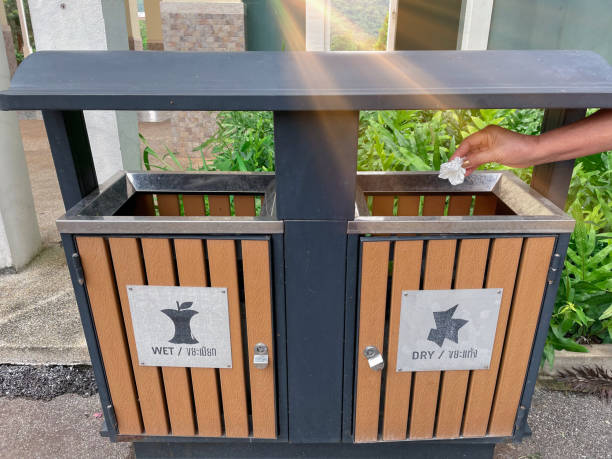 istock Asian old woman throwing tissues into the trash bin, Recycling bin,  Sort and dispose of items in appropriate bins. 1564748355