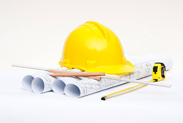 istock yellow construction helmet and rolls of architectural drawings 156475639