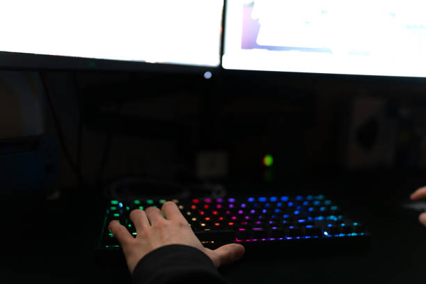 Young gamer play online with friends. Dark scene with gaming PC and lots of  RGB light Stock Photo - Alamy