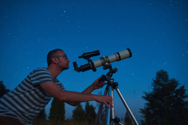 istock Astronomer looking at the starry skies with a telescope. 1564794868
