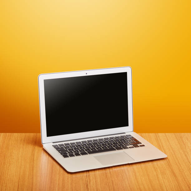 istock Real laptop computer on orange background with clipping path for the screen 1564804191