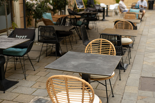 Empty restaurant summer terrace with tables and chairs. Reastaurant tables waiting for customers at an outdoor terrace