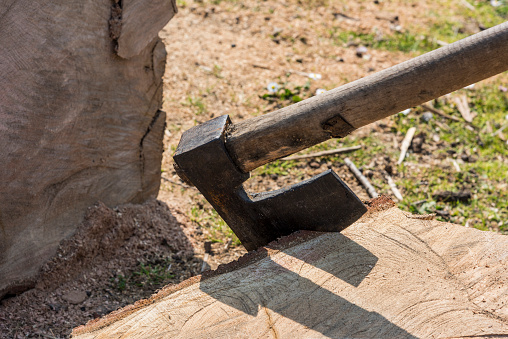 An axe lies on a deck, chopped firewood