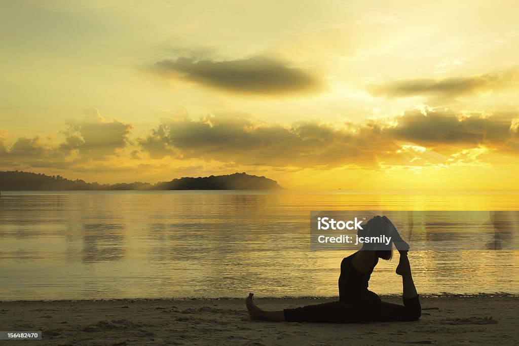 silhouette  beautiful yoga girl at sunrise on the beach silhouette of a beautiful yoga girl at sunrise on the beach Active Lifestyle Stock Photo