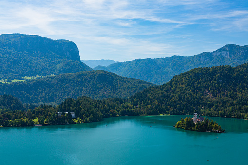 Bled is a beautiful town in Slovenia known for its stunning lake, Bled Lake, and an island with a church in the middle. The lake is surrounded by lush greenery and a castle on a cliff.