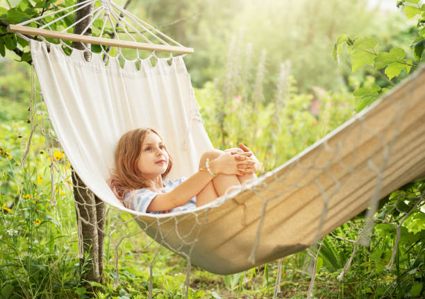 istock A little girl rests in a hammock and eats cherries in the summer. 1564850106