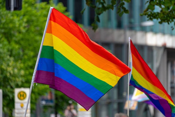 istock Berlin CSD 2023 - two Rainbow Flags in City against building 1564857192