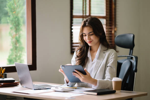 istock Asian businesswoman working in the office with working notepad, tablet and laptop documents 1564859800