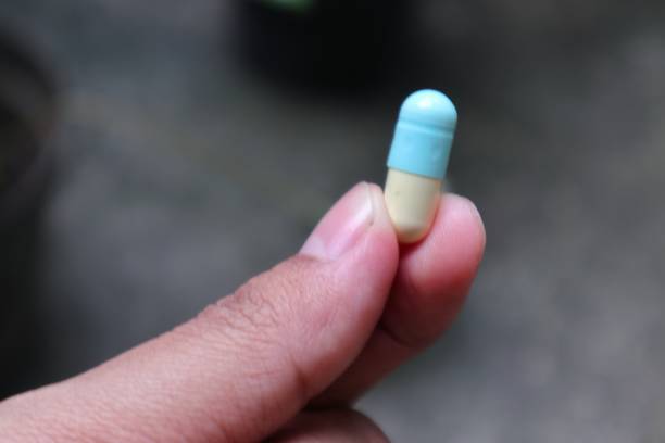 istock blue and white capsule pill on a hand 1564882448