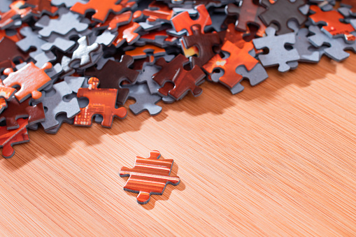 Colorful Peaces of a Mixed Jigsaw Puzzle Lie on the Wooden Table - Strategy and Solving Problem Concept