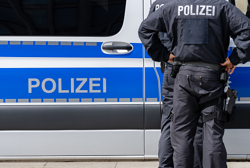 Two police officers in front of a police car, Berlin Potsdamer Platz