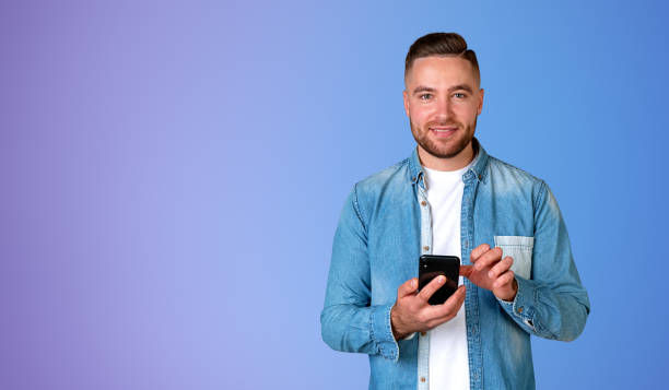 istock Smiling man with smartphone in hands, online payment copy space 1564960016