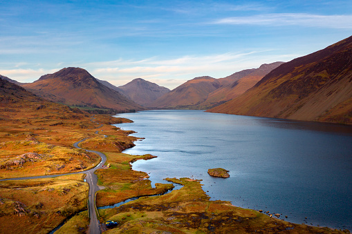 An aerial perspective of the lake at Wastwater in the Lake District, UK. Taken on a Winter evening, the lakeside road meanders to a stunning view of the Western fells, such as Great Gable, Yewbarrow and Scafell Pike.