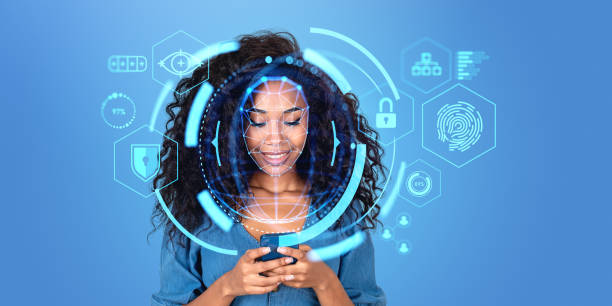 istock Smiling African woman using smartphone with facial recognition interface 1564968041