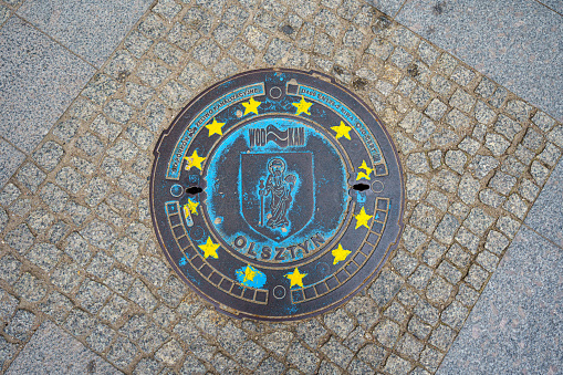 sewer manhole plate with the Olsztyn coat of arms