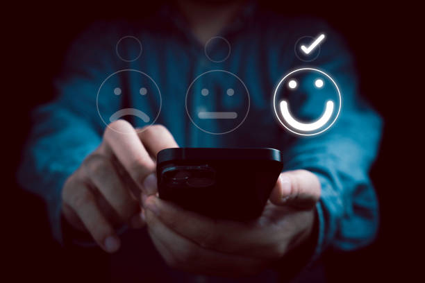 istock Businessman using smartphone to select  smile face for the best evaluation from client , customer satisfaction concept. 1564974504