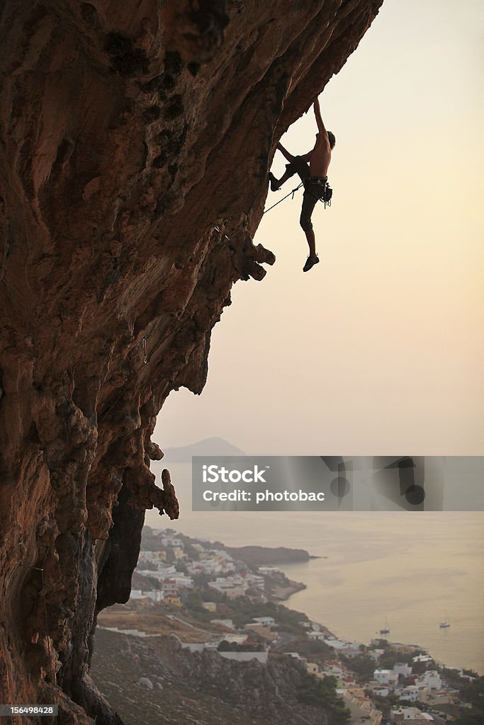 Рок альпинист на закате - Стоковые фото Скалолазание роялти-фри