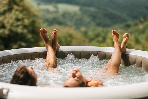 A young couple enjoying in hot tub with a view