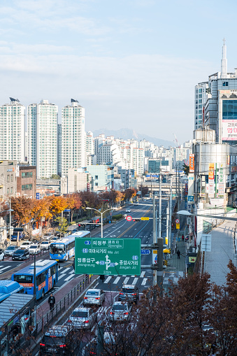 Seoul, South Korea - 24 November 2019: Building along the street in Seoul with colorful autumn trees