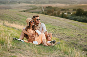 A young couple in Tuscany fields enjoying sunset