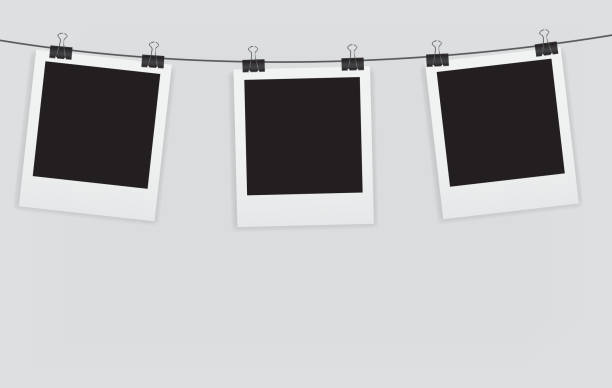 A picture of blank instant photos hanging on a line Instant photos with clip vector illustration. EPS10. Contains transparent objects used for shadows drawing, glare and background. Background to give the gloss. wire photos stock illustrations