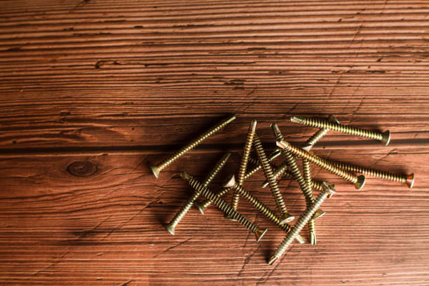 istock screws on wood background 1565040254