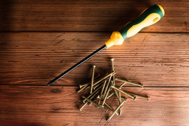 istock screws on wood background 1565046845