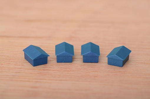Blue plastic toy houses. Concept of deposits and mortgages required by first-time home buyers