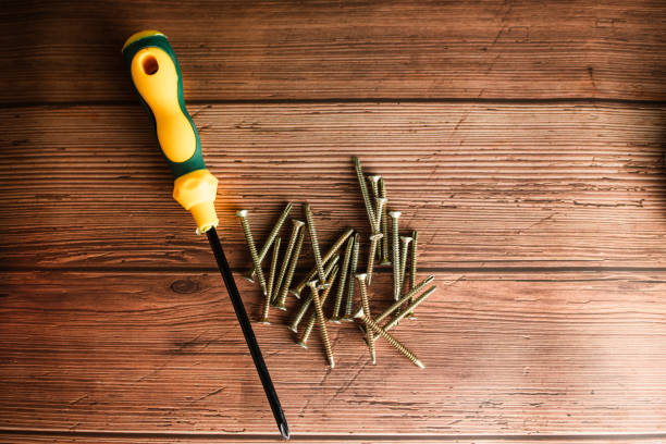 Tapping screws made of steel on wood background, metal screw, iron screw, chrome screw, screws as a background, wood screw, concept industry. copy space for text.
