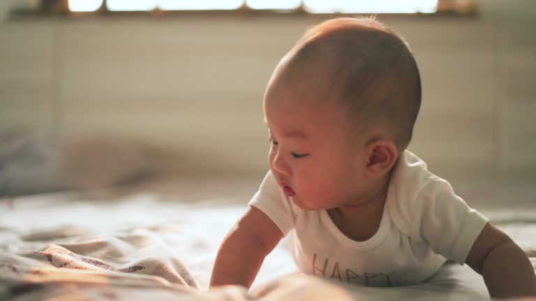 Happy little baby boy smiling and happy in the morning on baby bed in bedroom