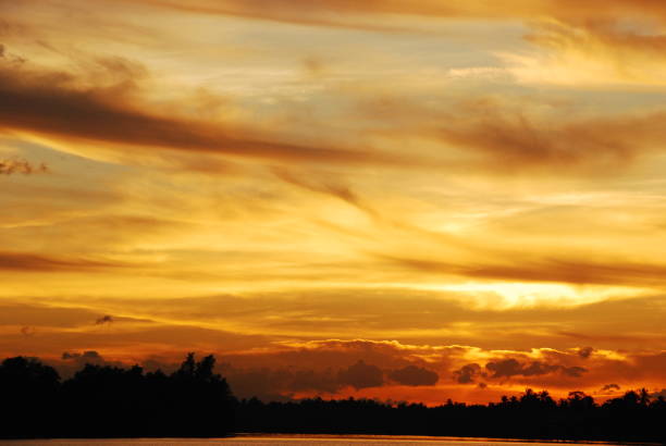 Scenic view dramatic beautiful sunset sky. Natural Sunset Sunrise on meadow silhouette shadow dark land. Vibrant dramatic sky on sunset, dawn, sunrise in Countryside. Landscape Colorful Sky At Sunset