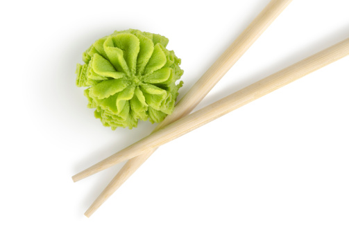 Wooden chopsticks and wasabi isolated on a white background