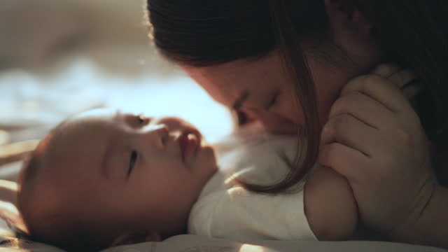Mother playing with her baby in morning time after wake up