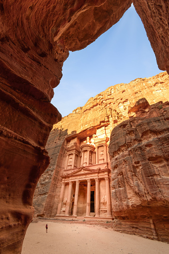 View of the Al-Khazneh Palace or Treasury in Petra, Jordan. The building is carved into a huge rock, has an elegant pediment and towering columns.