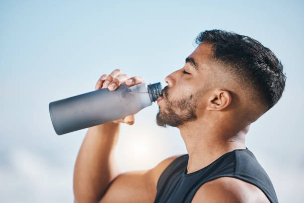 fitness, człowiek i woda pitna na świeżym powietrzu po treningu, bieganiu lub porannej rutynie cardio. pragnienie, nawodnienie i indyjski biegacz z butelką napoju po sporcie, treningu i wydajności ciała - water bottle sports and fitness selective focus sport zdjęcia i obrazy z banku zdjęć