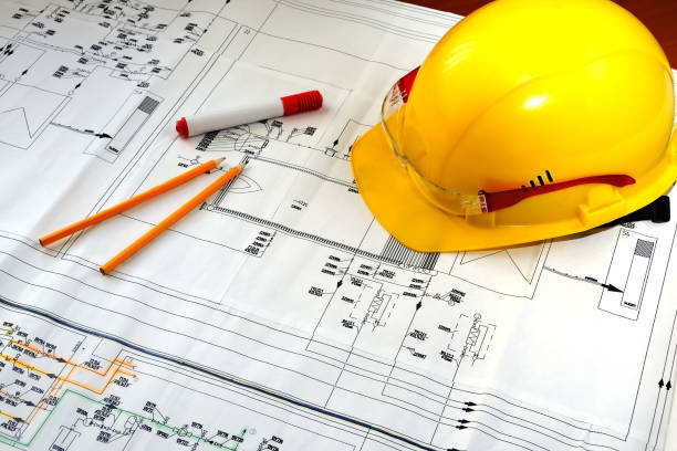 istock Yellow hard hat and goggles lie on the engineering scheme 1565095661